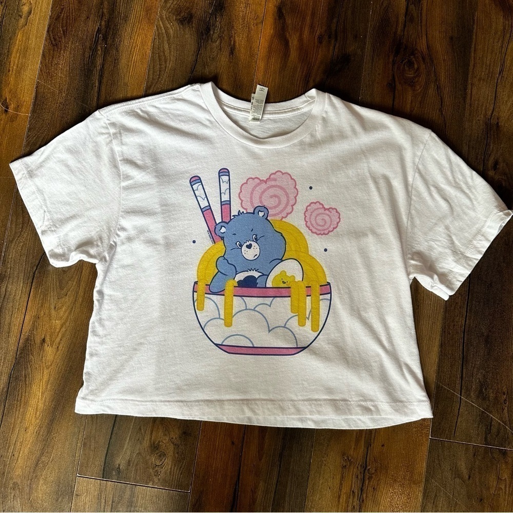 Ideal T by Next Level | Care Bears Grumpy Ramen Bowl Cropped Tee | Medium